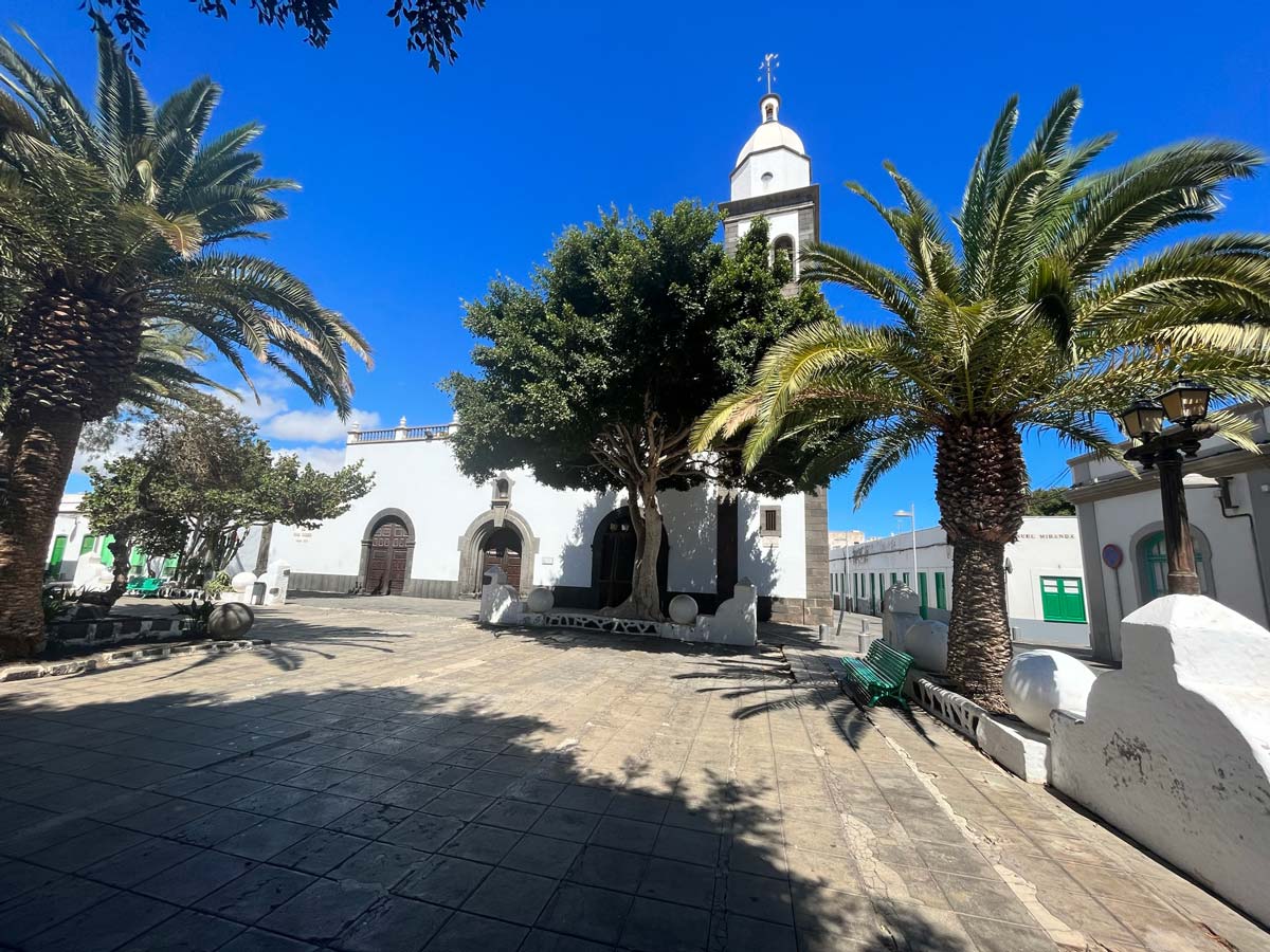 10 Fabulous Things to Do in Arrecife, Lanzarote 1 small colonial squate with palm trees and a whitewashed church with bell tower