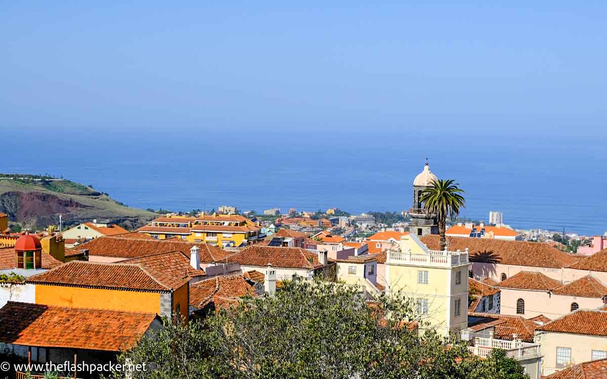 Tenerife Solo Travel: The Ultimate Guide 1 skyline of a colonial town in tenerife spain with one large palm tree and sea on distance