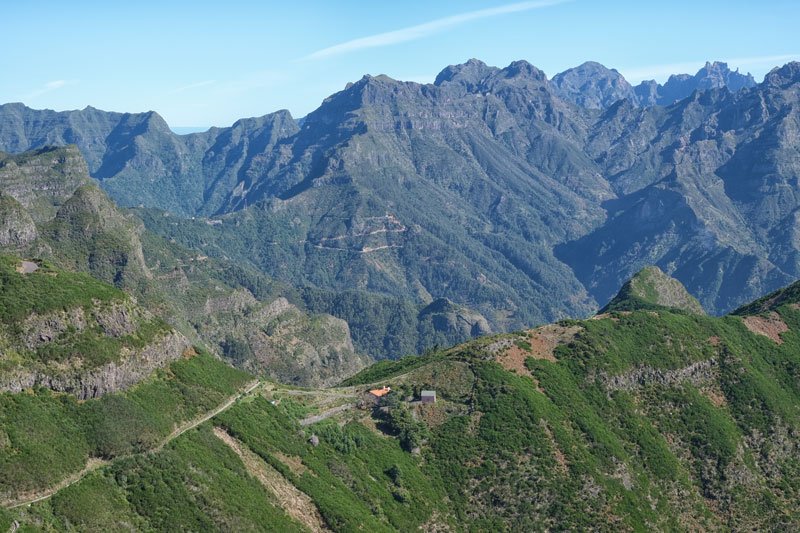 landscape in madeira with a deep valley and granite slopes and small house
