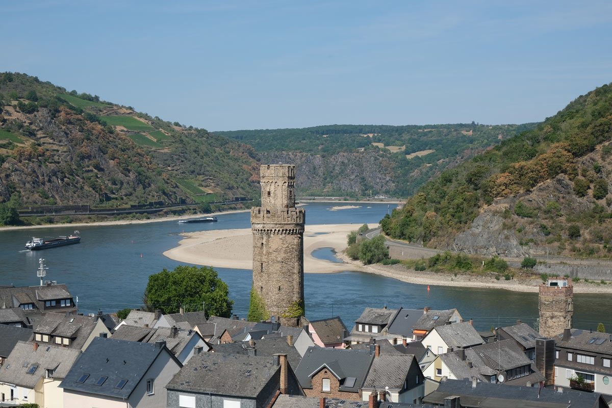 12 Wonderful Things to Do in Oberwesel, Germany 1 2 tall towers and the grey rootfops of the town of oberwesel germany against the background of a bend in the river rhine