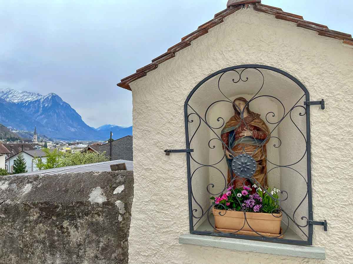 Is Vaduz Worth Visiting? 5 Reasons to Say Yes! 1 shrine set into the wall with an alpine valley in background