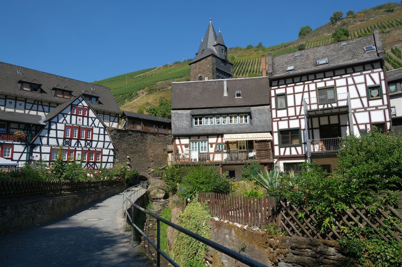 beautiful half-timbered buildings and a small bridge over a stream in the town of bacharach in Germany