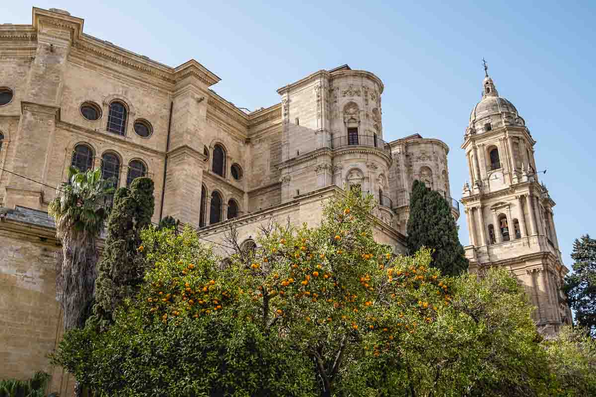 Málaga Cathedral: Gothic Grandeur and Spanish Renaissance 1 exterior of malaga cathedral with bell tower and orange tress