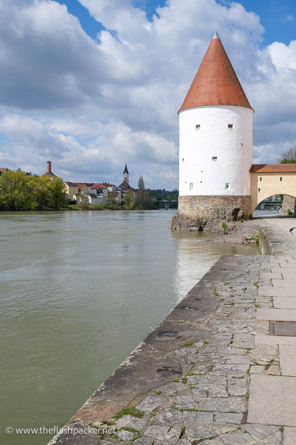 round white stone tower with a conical red roof