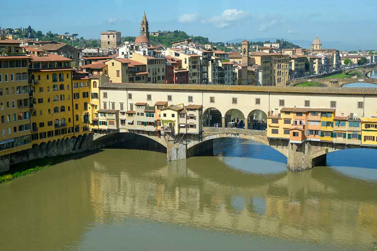 view of ponte vecchio bridge in florence reflected in water of river