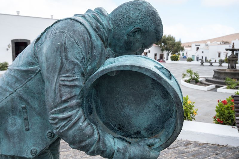 bronze sculpture of a man playing the tambourine in a colonial square in Teguise which is a place to see during a Lanzarote solo travel trip