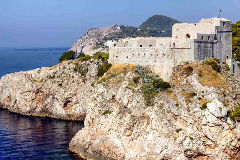 white fortress on cliff overlooking sea in dubrovnik