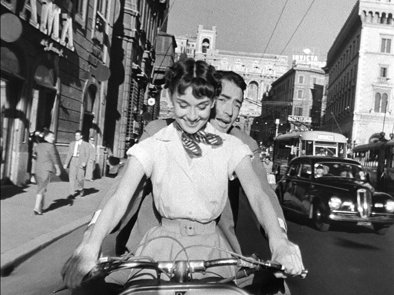 Audrey_Hepburn_and_Gregory_Peck_on_Vespa_in_Roman_Holiday