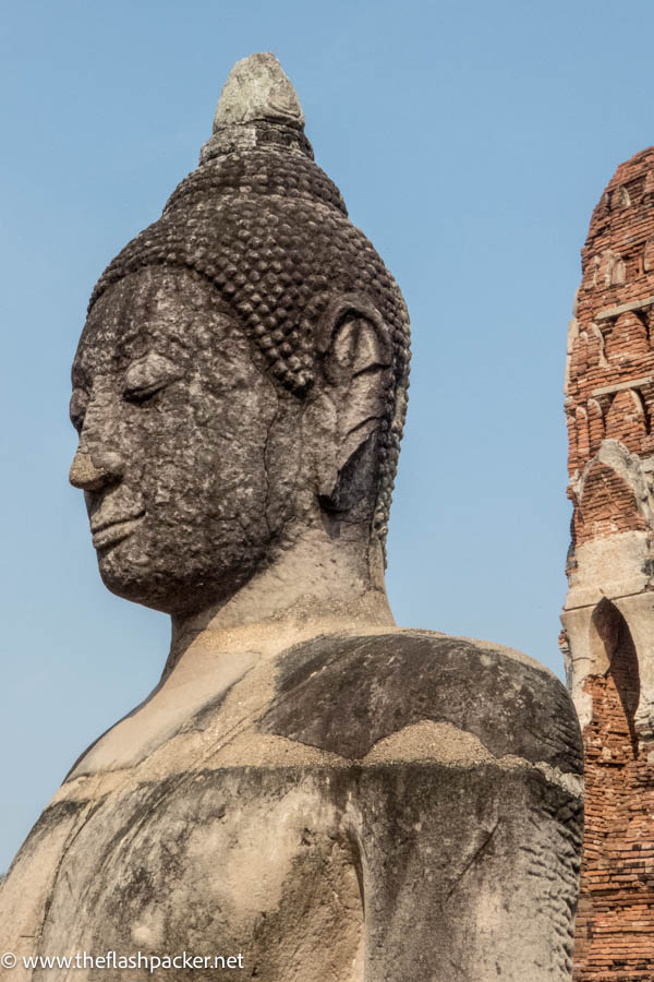 Thailand 5 head of buddha with ruined temple buildings in background