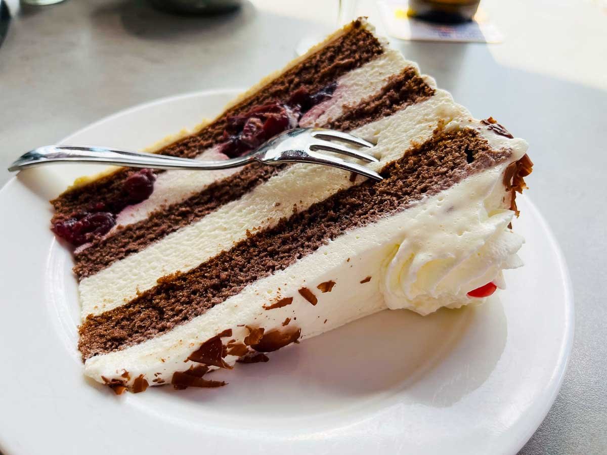 slice of black forest cake on a white plate with fork