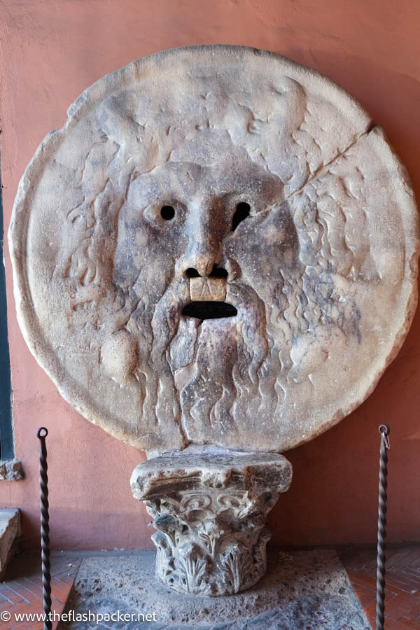 stone sculpture of the face of a mythical creature which is la bocca della verita in rome