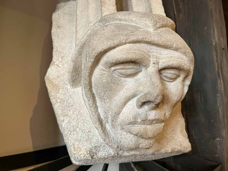 stone carving of the head of a figure with his eyes shut