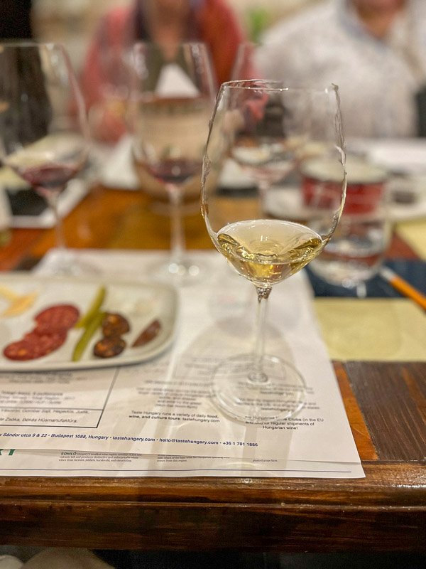 glass of white wine next to some charcuterie