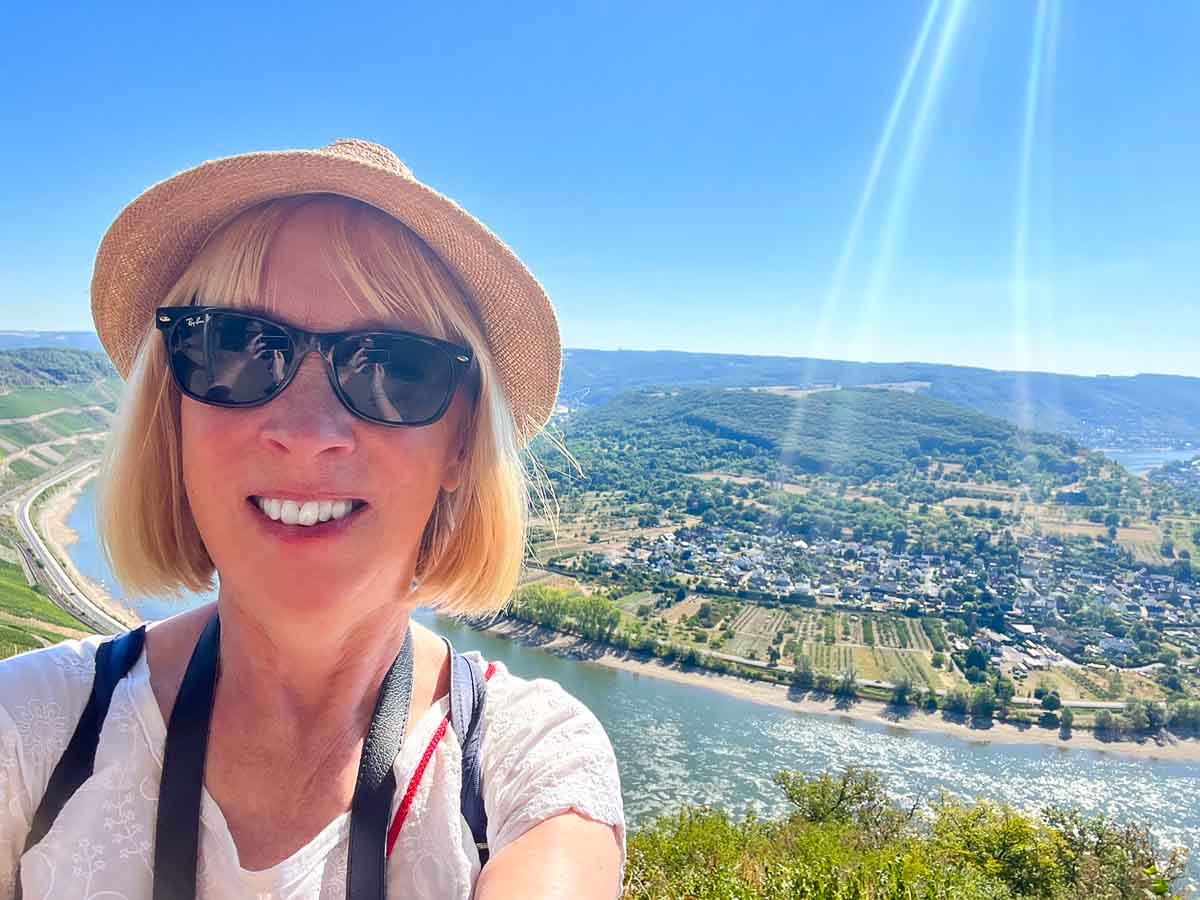 Europe 1 woman in sunglasses and hat in front of a rhine river view