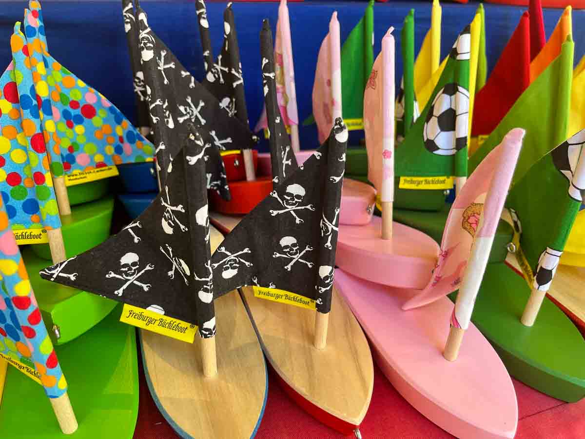 group of brightly coloured small wooden boats with sails