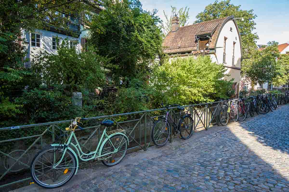 bikes against a railing alongside a pretty canal