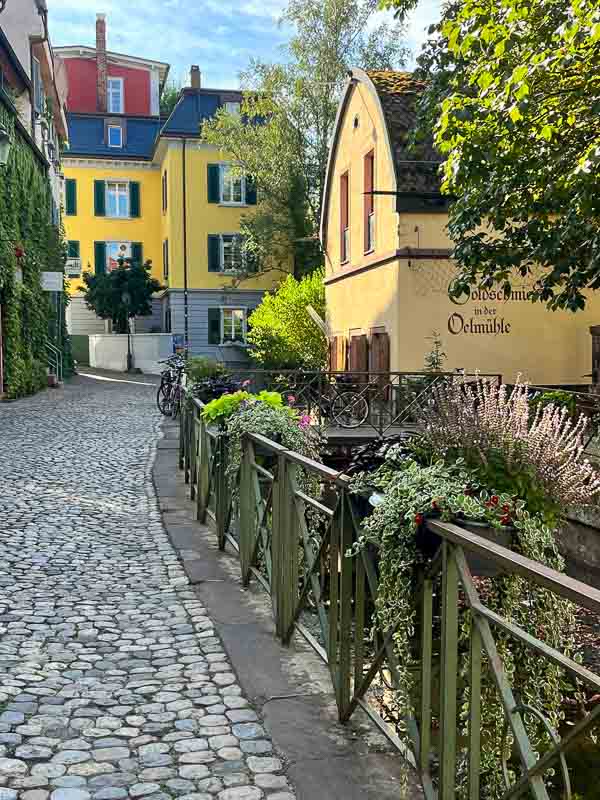 cobbled path leading to yellow coloured buildings