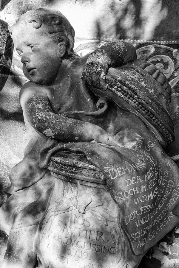 funerary stone sculpture of cherub with german writing