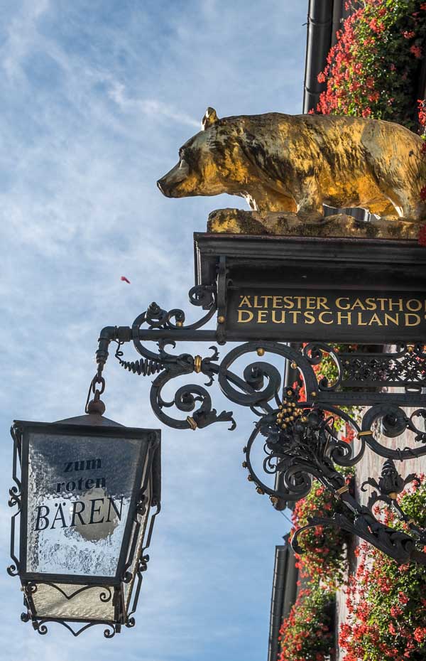 sign over a bar with a bear and an old lamp