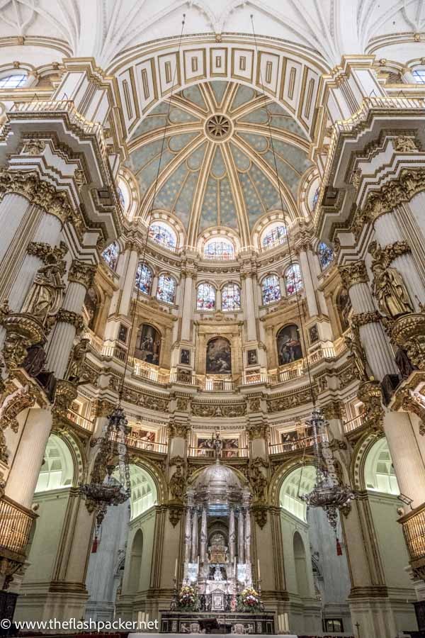 ornate interior of cathedral in granada with altar and tiered dome
