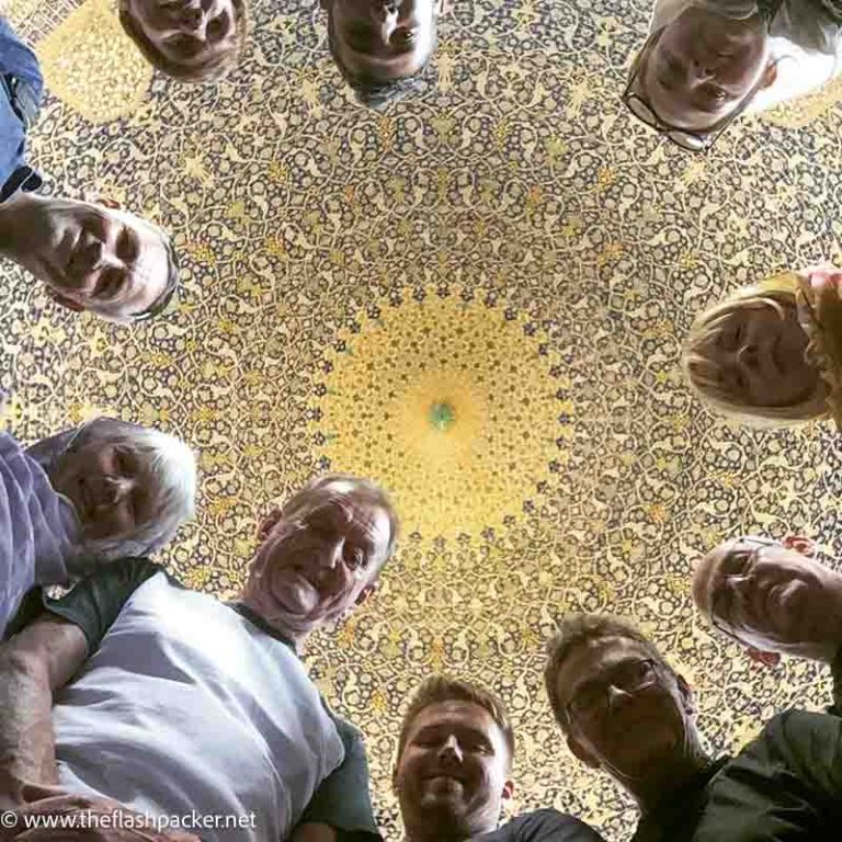 10 Tips for Choosing a Small Group Tour That's Perfect for You 1 a group of people looking up at an interior dome of mosque