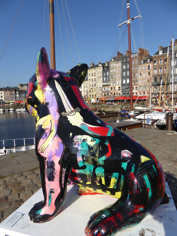 statue of huge painted cat overlooking harbour with boats and houses in honfleur normandy