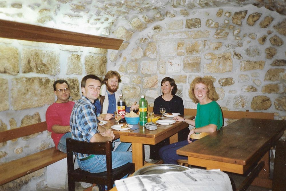 How to Travel Alone For The First Time in 7 Easy Steps 1 group of people eating sitting around table