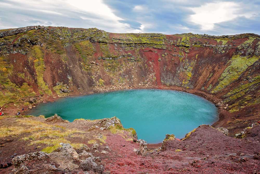 bright blue lake in a volcanic caldera with red rocks