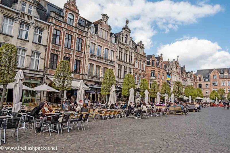 people sitting at outdoor cafes in a beautiful square in belgium