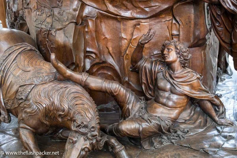 wooden sculpture of man falling off horse