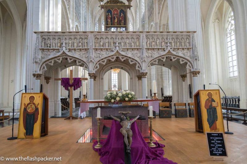 intricate rood screen in church carved from white stone