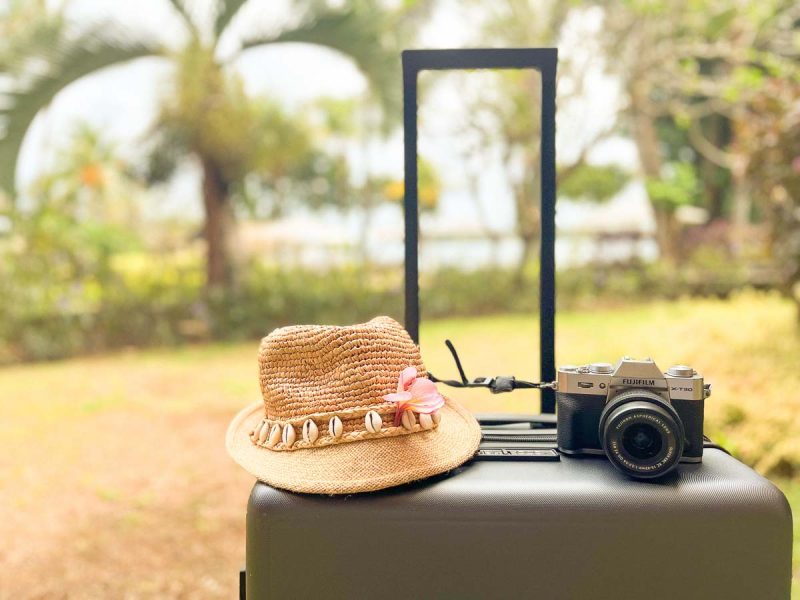 Flashpacking 2 camera and straw hat on top of LEVEL8 suitcase
