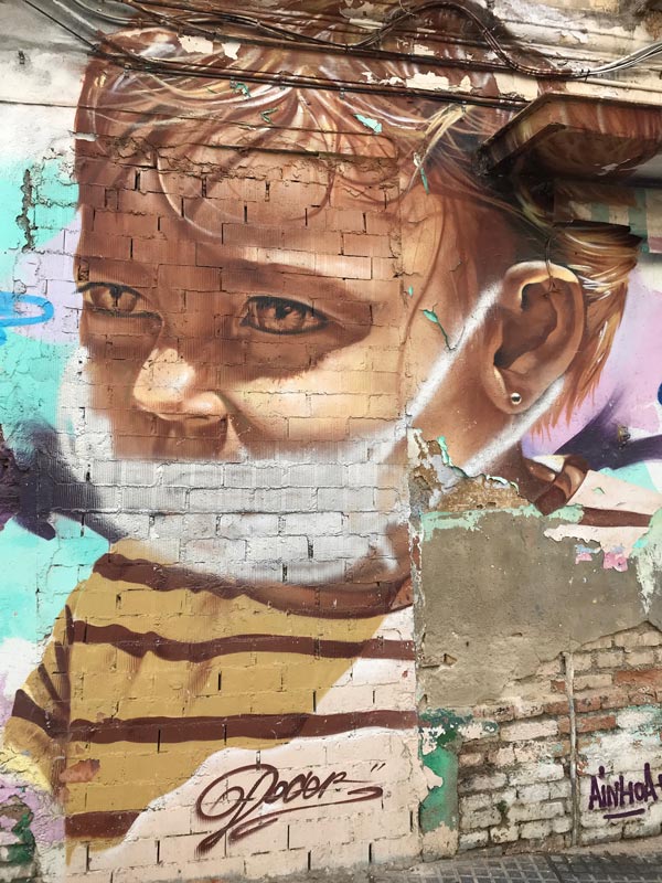 street art in malaga spain of young child wearing face mask