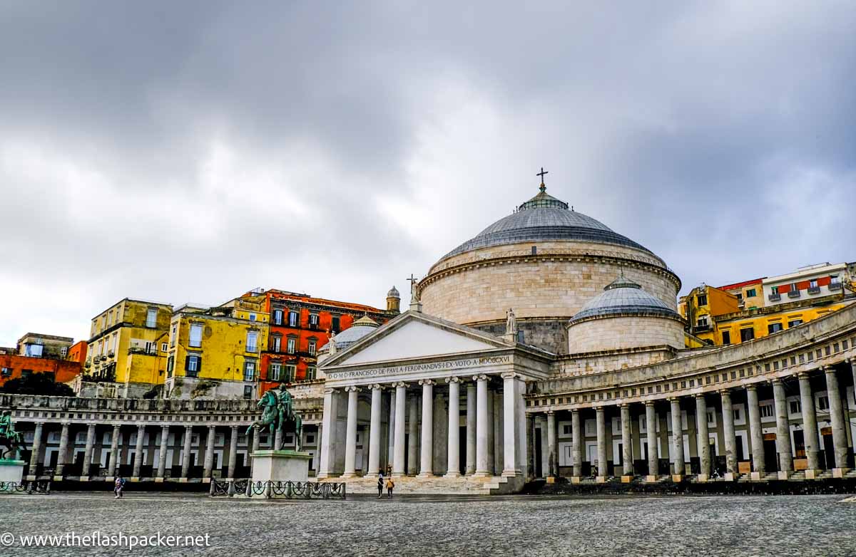sweeping collonaded building on one side of square in naples italy