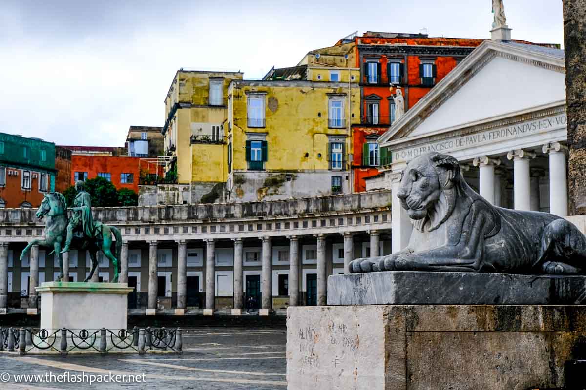 statues of lion in front of colonnaded building in piazza
