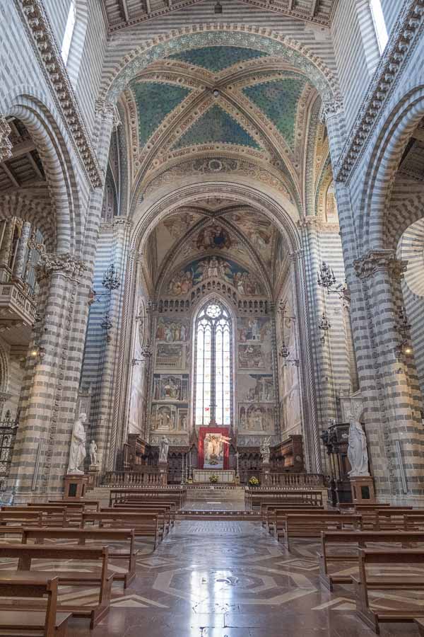 nave of orevieto cathedral with striped stonework and soft light