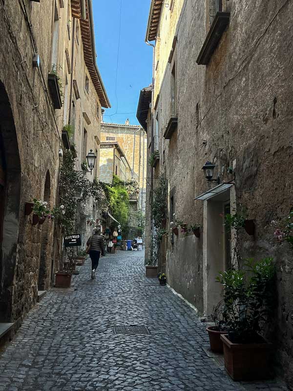woman walking along a narrow street in orvieto italy