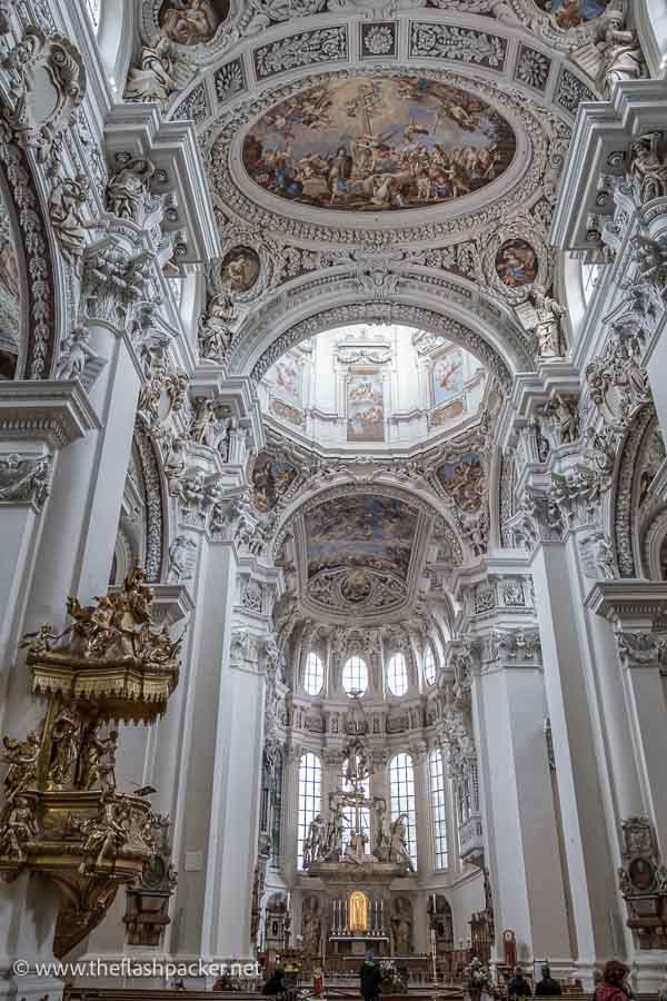 grey-white interior of church with stucco decorations and ceiling fresco