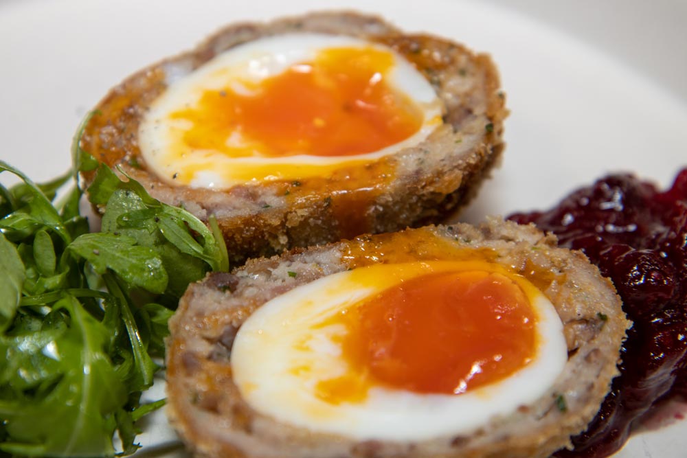 two scotch eggs on a plate