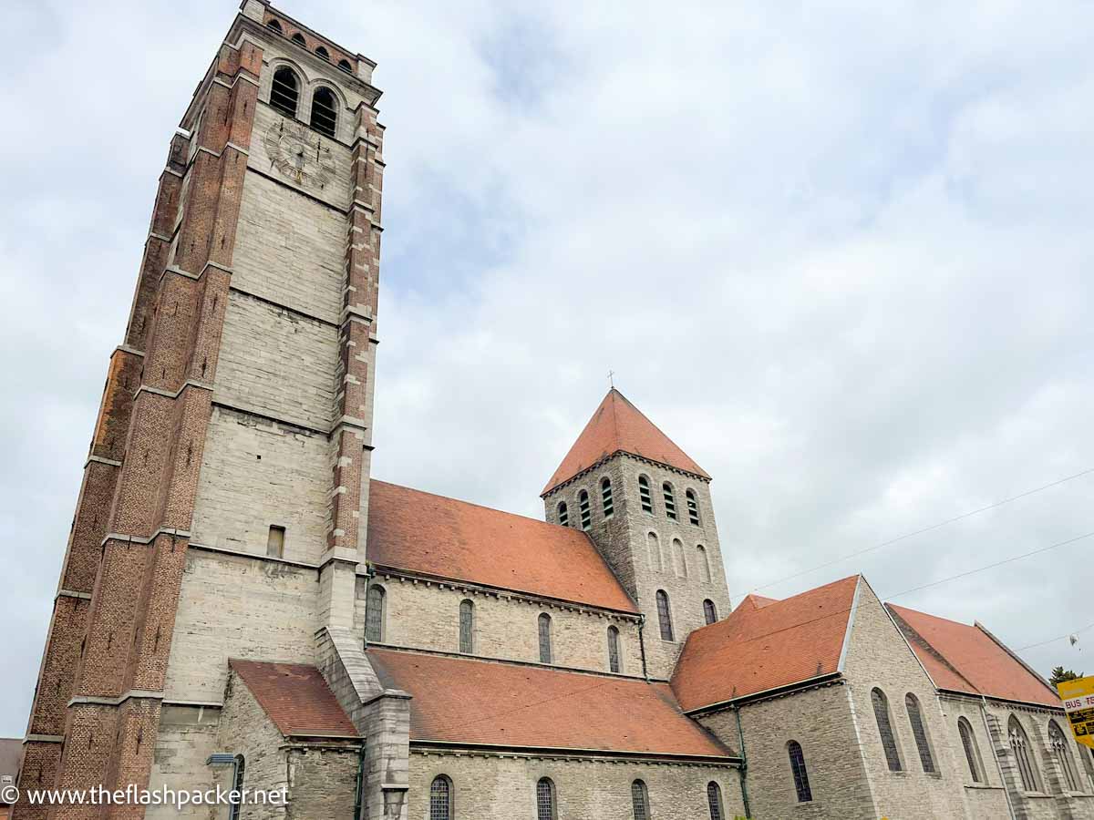 exterior of saint brice church in tournai with red rooftops and tall bell tower