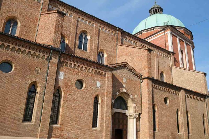 red brick exterior of vicenza duomo with copper-covered dome