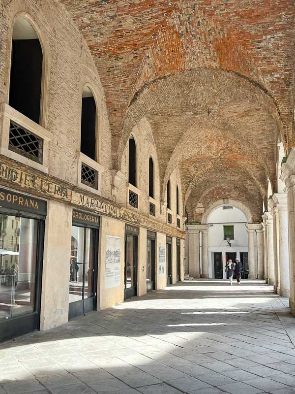2 women walking along a portico in vicenza italy